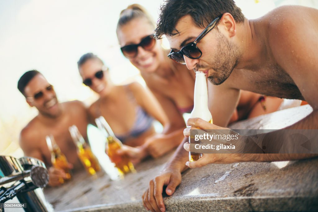 People drinking beer at beach bar.