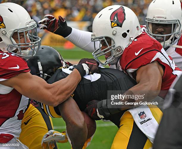Safety Tyrann Mathieu and linebacker Kevin Minter of the Arizona Cardinals tackle wide receiver Antonio Brown of the Pittsburgh Steelers during a...