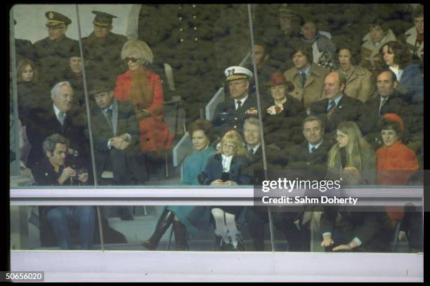 Newly elected US President Jimmy Carter and Vice President Walter Mondale sitting with their familes in the reviewing stands for Inaugural Parade.