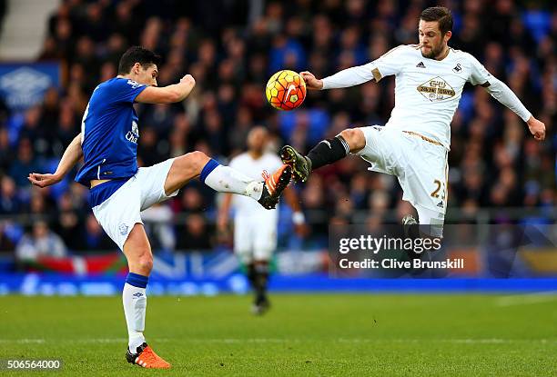 Gylfi Sigurdsson of Swansea City battles for the ball with Gareth Barry of Everton during the Barclays Premier League match between Everton and...