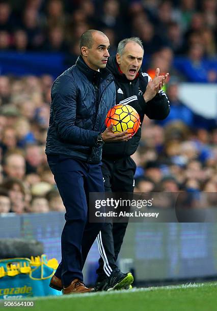 Francesco Guidolin, Manager of Swansea City encourages his players next to Roberto Martinez, Manager of Everton during the Barclays Premier League...