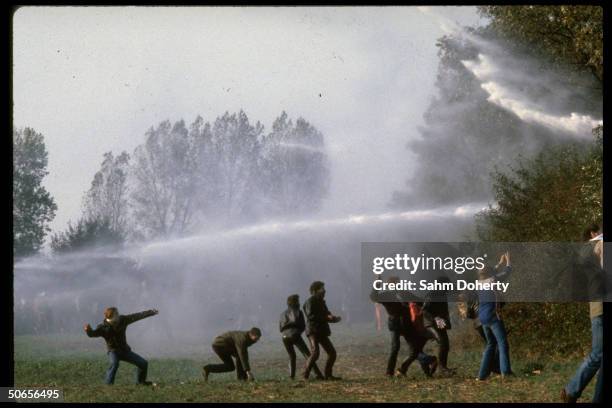 West German police using water cannon on protestors as they hurl rocks in retaliation during anti-nuclear demonstration outside the Honnepel reactor.