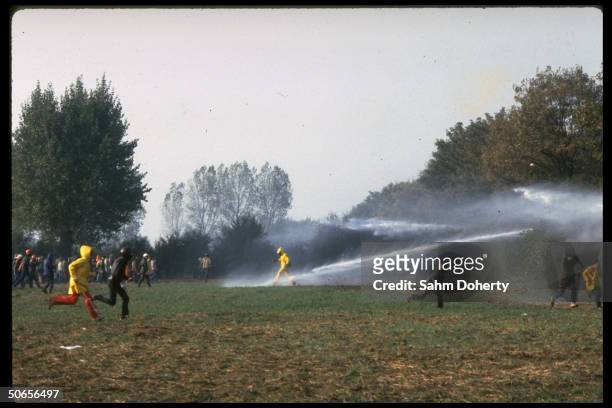 West German police using water cannon on protestors as they hurl rocks in retaliation during anti-nuclear demonstration outside the Honnepel reactor.