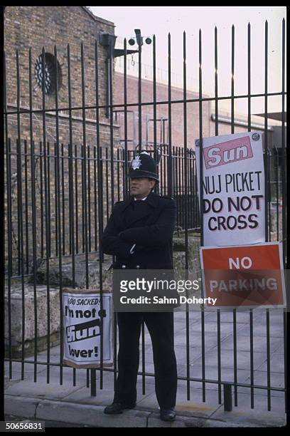 Police officer standing outside gate of newspaper owner Rupert Murdoch's Wapping, London plant, aka Fortress Murdoch, during printworkers union...