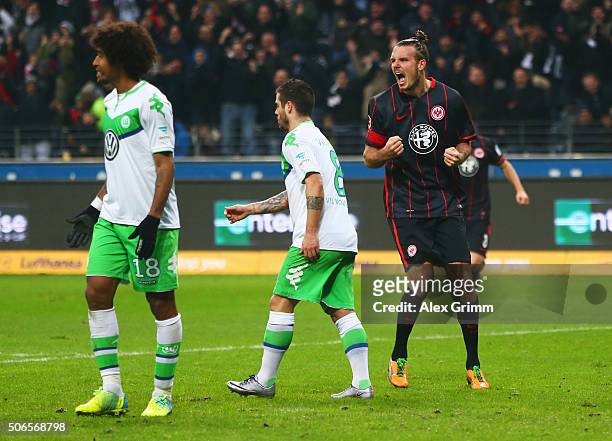 Alexander Meier of Eintracht Frankfurt celebrates as he scores their first and equalising goal as Dante and Vierinha of VfL Wolfsburg look dejected...