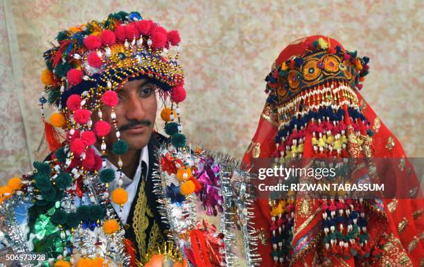 Pakistani Hindu bride and groom attend a mass wedding ceremony in Karachi on January 24, 2016. - Some 60 Hindu couples took part in a mass wedding...