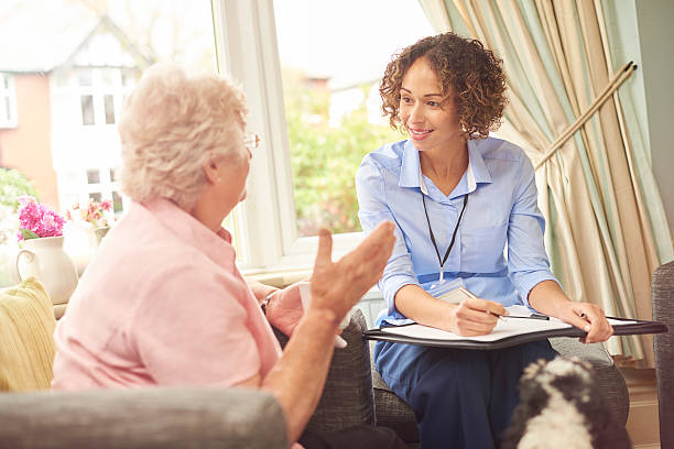 a nurse and an older woman talking by a window