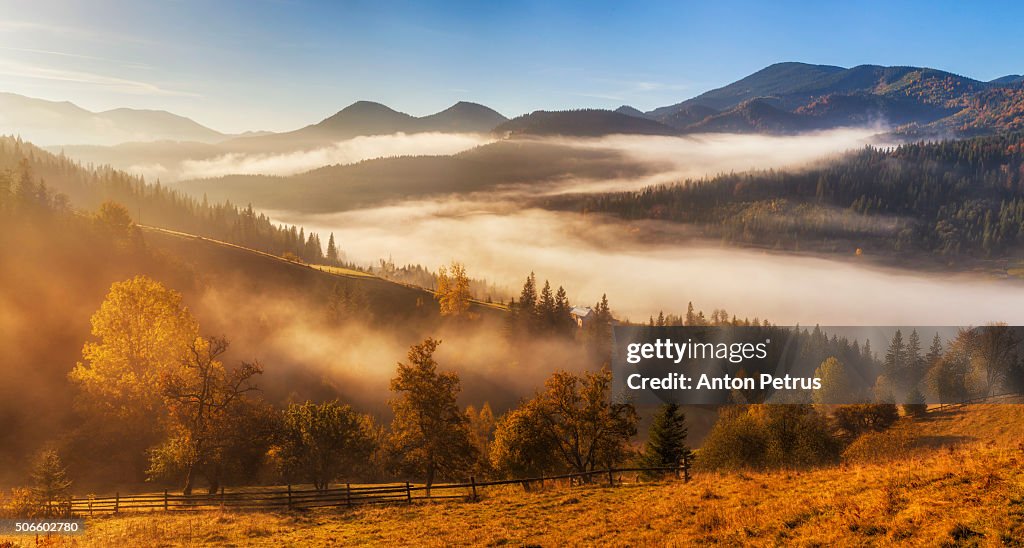 Panorama of misty sunrise in the mountains