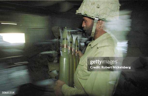 Pakistani soldier loading anti-aircraft gun in cave at LOC artillery position, gearing to fire on passing Indian Army convoy in escalating conflict...