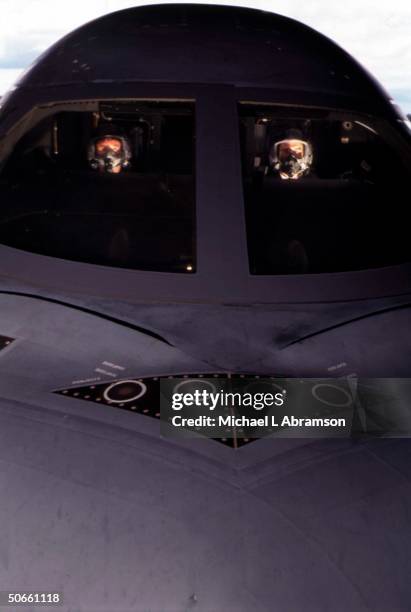 Masked pilots in cockpit of B-2 stealth bomber at Whiteman Air Force Base