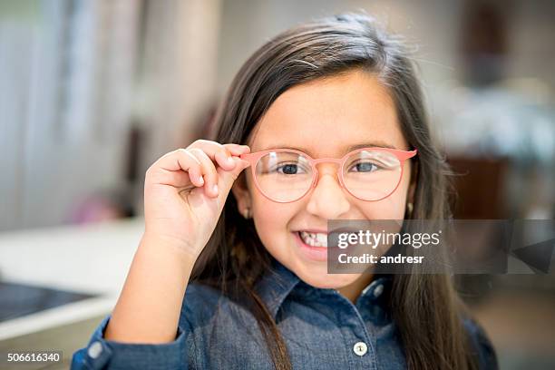 chica probando gafas en la óptica - gafas fotografías e imágenes de stock