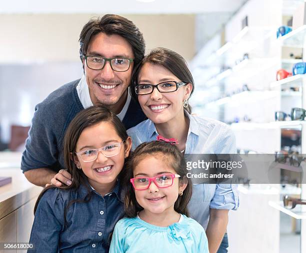family buying glasses at the optician's shop - spectacles stock pictures, royalty-free photos & images