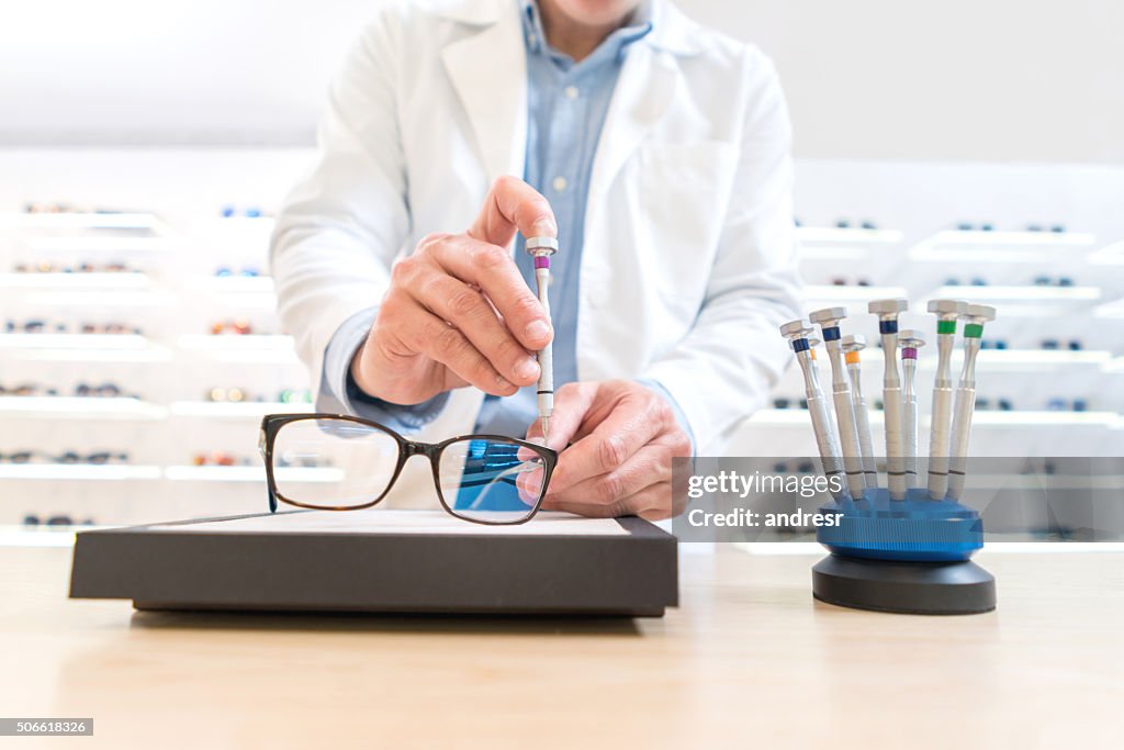 Uomo che ripara gli occhiali all'ottica