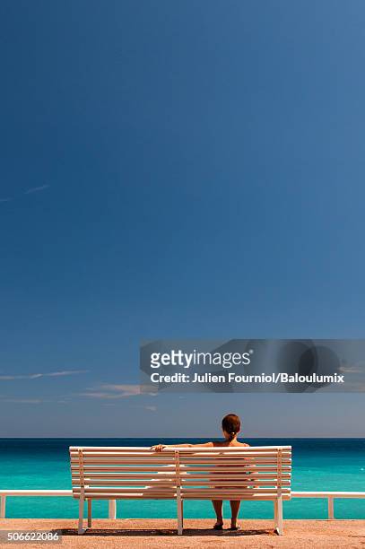 contemplation on a bench facing the sea - プロムナーデザングレ ストックフォトと画像
