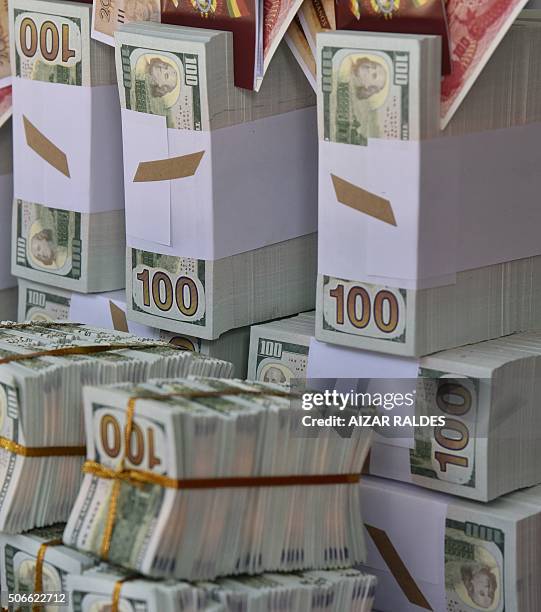 Woman sells fake 100-dollar bills at the start of the Alasitas festival on January 24 , 2016 in La Paz. The month-long annual cultural event honors...