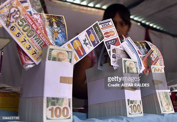 Woman sells fake 100-dollar bills at the start of the Alasitas festival on January 24 , 2016 in La Paz. The month-long annual cultural event honors...