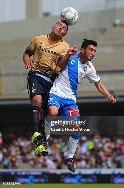 Javier Cortes of Pumas fights to head the ball against Christian Bermudez of Puebla during the 3rd round match between Pumas UNAM and Puebla as part...