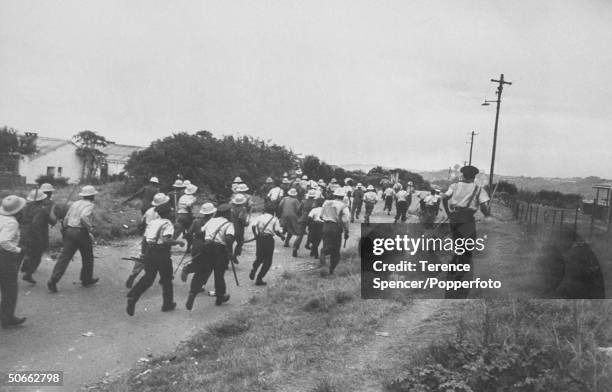 South African police advance in an attempt to regain order as protestors from the township of Sharpeville demonstrate against government pass laws...