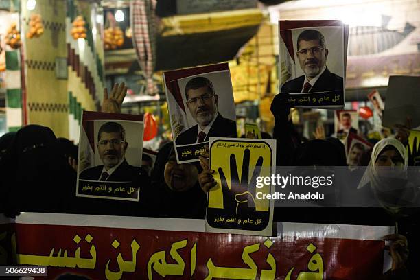 People carry posters of first democratically elected President of Egypt Mohamed Morsi and "Rabia Sign" during the protest against military regime on...