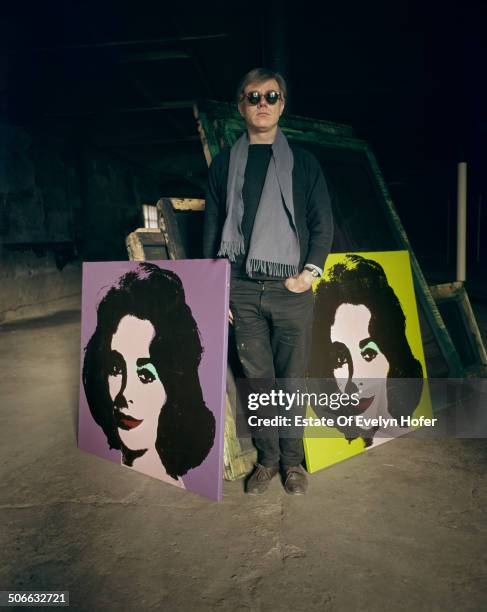 American pop artist Andy Warhol with two prints of actress Elizabeth Taylor, New York, 1964.
