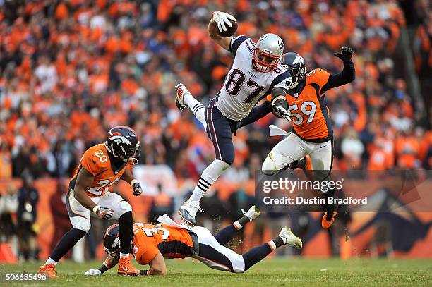 Rob Gronkowski of the New England Patriots is tackled by Josh Bush, Shiloh Keo and Danny Trevathan of the Denver Broncos in the fourth quarter in the...