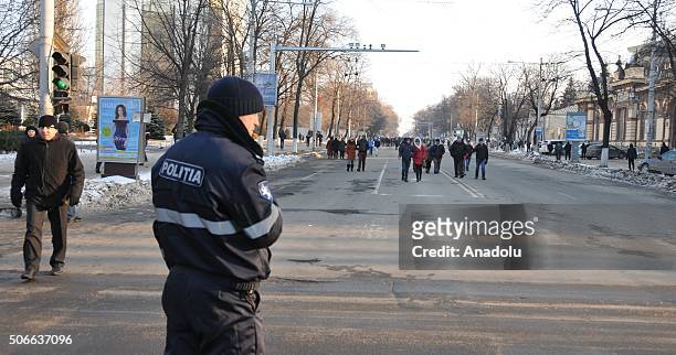 Policeman stands guard as opponent Moldovans arrive for an anti-government protest, demanding resignation of the government and early elections, in...