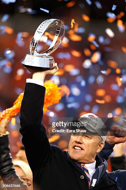 General Manager and Executive Vice President of Football Operation for the Denver Broncos John Elway holds up the Lamar Hunt Trophy after defeating...