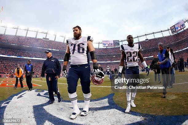 Sebastian Vollmer and Justin Coleman of the New England Patriots walk off the field with teammates after being defeated by the Denver Broncos in the...