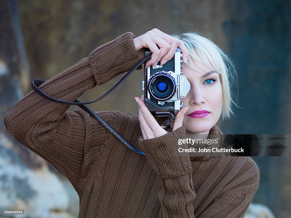 Blue-eyed blonde with an old SLR camera