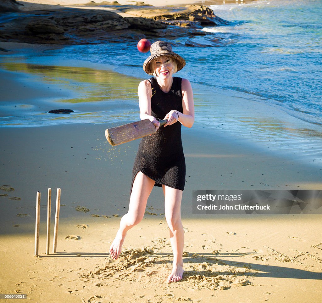 Blonde playing beach cricket