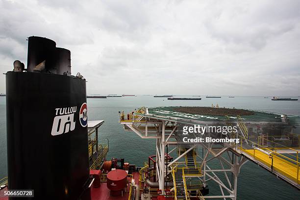 Oil tankers are seen beyond the heli-deck of the Tullow Oil Plc Prof. John Evans Atta Mills Floating Production Storage and Offloading vessel docked...