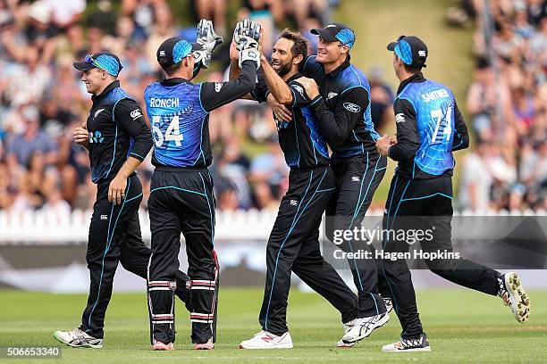 Grant Elliott of New Zealand celebrates with Luke Ronchi and Martin Guptill after taking the wicket of Sohaib Maqsood of Pakistan during the One Day...