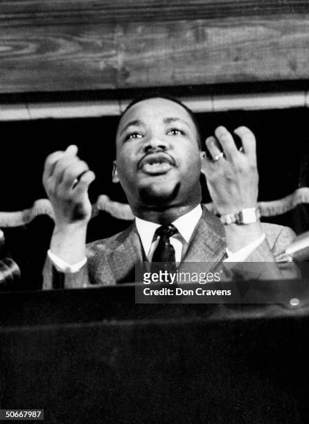 Civil rights leader Rev. Martin Luther King speaking from pulpit at mass meeting about principles of non-violence before leading assembly to ride...
