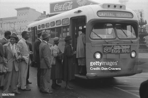 African Americans boarding an integrated bus through the once-forbidden front door, following Supreme Court ruling ending successful 381 day boycott...
