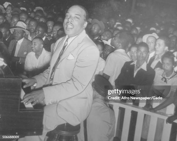 African-American jazz musician Count Basie, with a crowd, playing the piano during a concert, November 2, 1940.