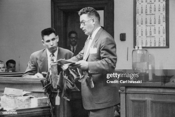 Defendant, Jack Graham on the witness stand trying to identify a piece of his mother's suitcase for Defense Counsel John Gibbons during his trial for...