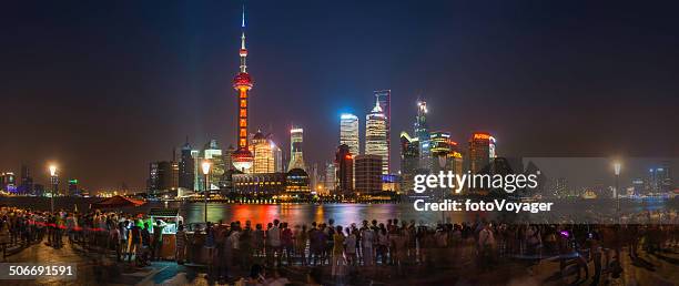 shanghai crowds on bund overlooking futuristic neon skyscrapers pudong china - oriental pearl tower stock pictures, royalty-free photos & images