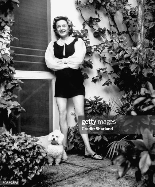 Anne McDonnell Ford, wearing dark shorts and vest and an organdy blouse with outsize sleeves, on the ocean terrace of husband Henry Ford II's Palm...