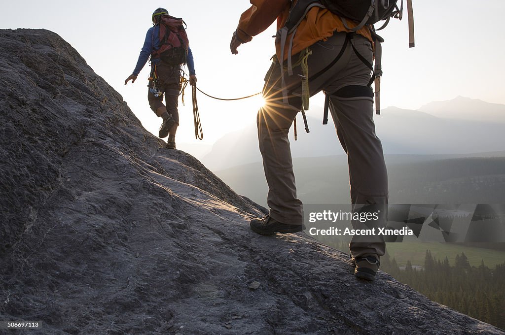 Climbers ascend mountain ridge, sunrise