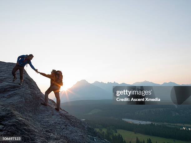 mountaineer offers a helping hand to teammate, mtn - clear sky stock pictures, royalty-free photos & images