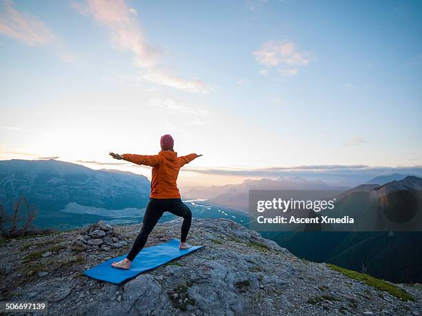 woman assumes yoga position on high mtn crest - mat stock pictures, royalty-free photos & images