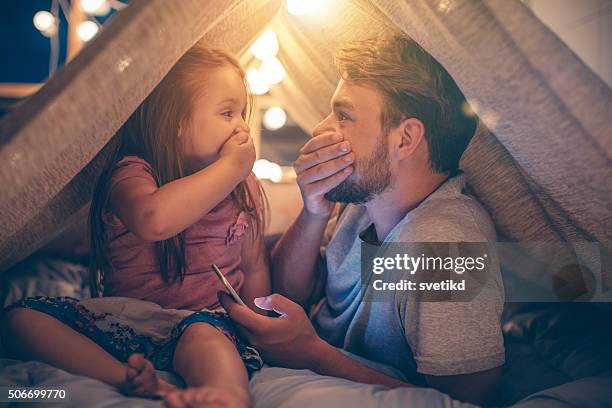 father and daughter enjoying at home. - camping at night stockfoto's en -beelden