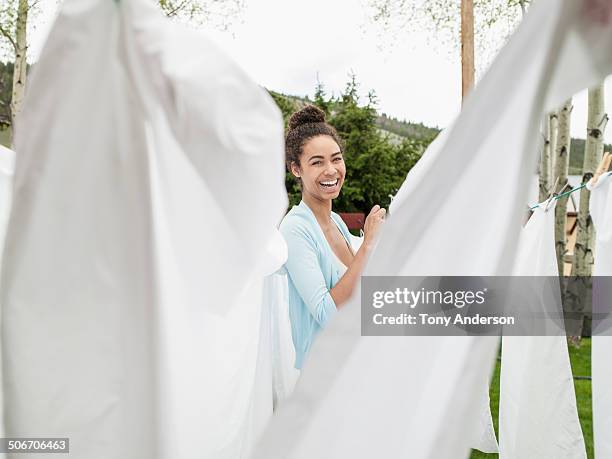 young woman hanging the laundry outdoors - washing-line stock pictures, royalty-free photos & images