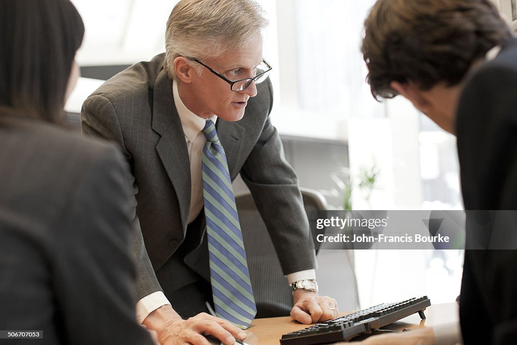 Three business colleagues at a computer