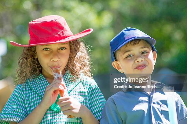 cheeky children and ice pops - hat stock pictures, royalty-free photos & images