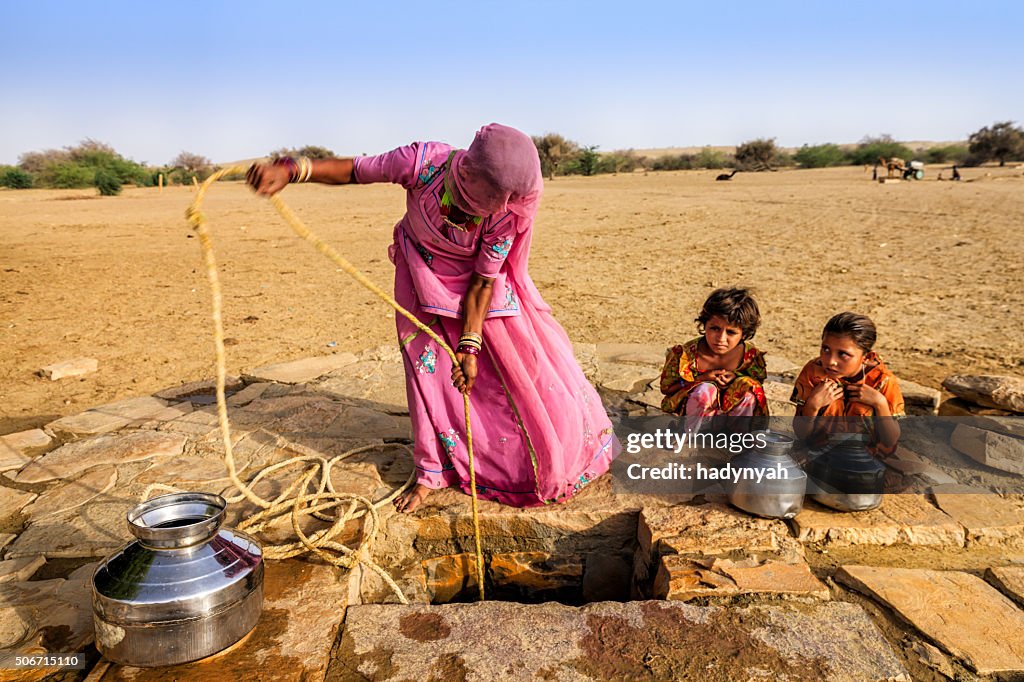 Indian woman drawing water from the well, desert, Rajasthan