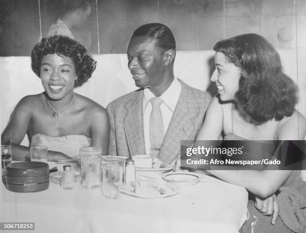 Nat King Cole, singer Sarah Vaughan and Marie Cole eating a meal during a celebration of an appearance on the Ed Sullivan show, November 11, 1950.