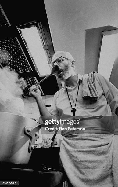 Episcopal minister & author-chef Father Robert F. Capon sampling cooking.