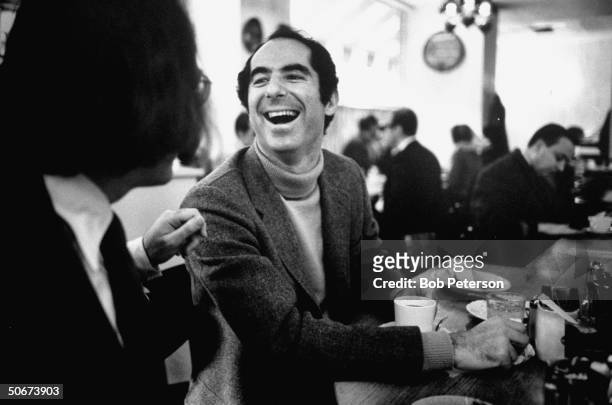 Author Philip Roth, revisiting areas where he grew up, sitting at lunch counter in Newark, New Jersey, talking to a customer.