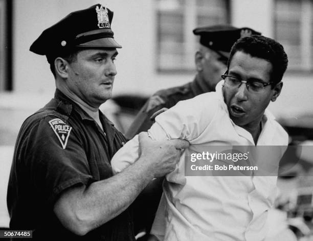 Policeman arresting a suspect during riots.